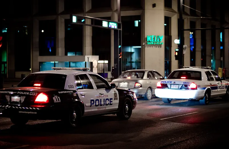 Police cruisers on a city street at night
