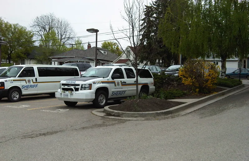 Marked BC Sheriff Service vehicles parked outside a court facility